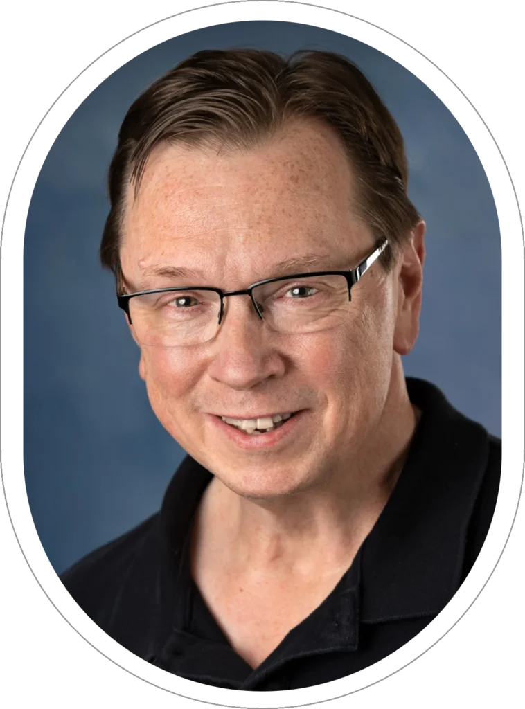 A man with glasses is smiling for the camera.